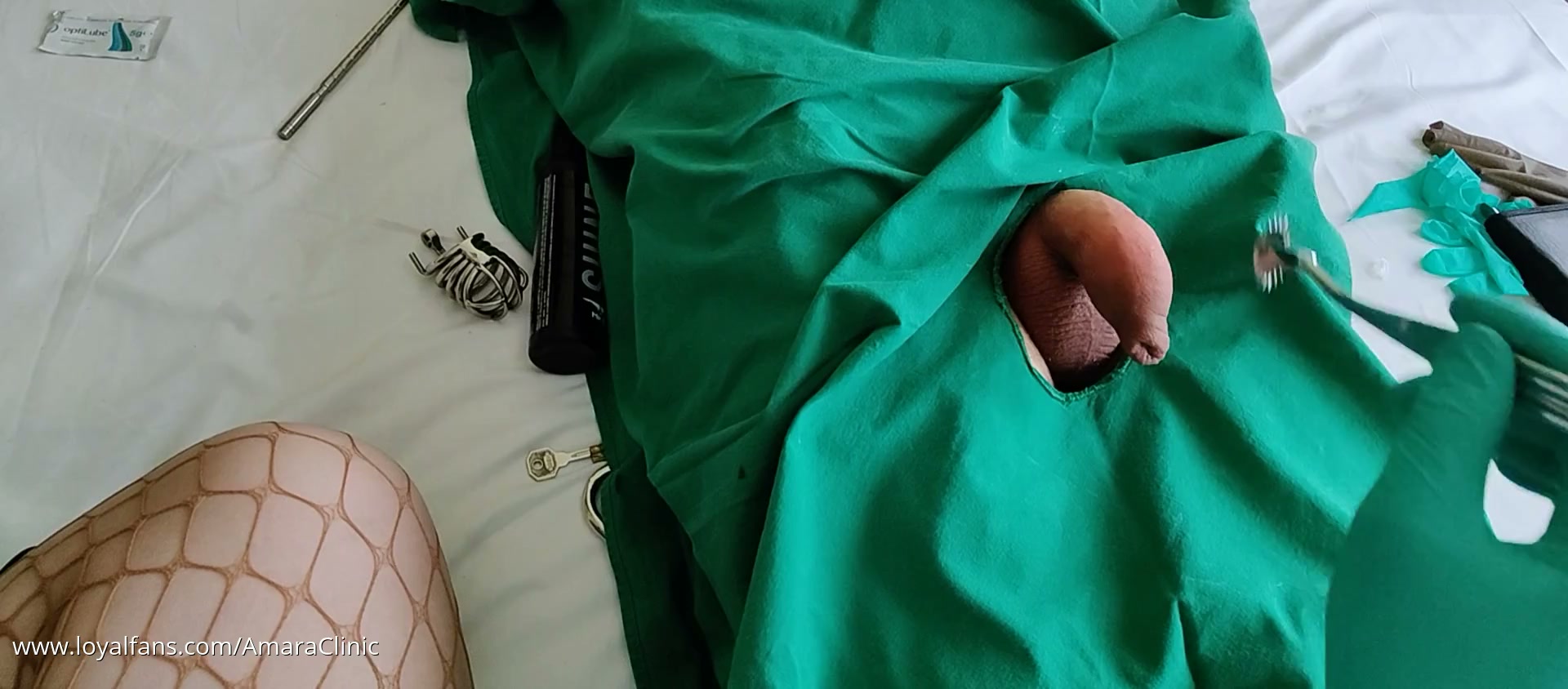 Mistress Katharina Amara with surgical gloves playing in the travel clinic hotel room before the clinical teasing of her patient